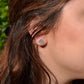 silver post earrings flower design worn by woman